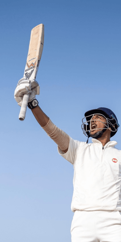 A Professional Cricket Player Holding a Bat in the Air